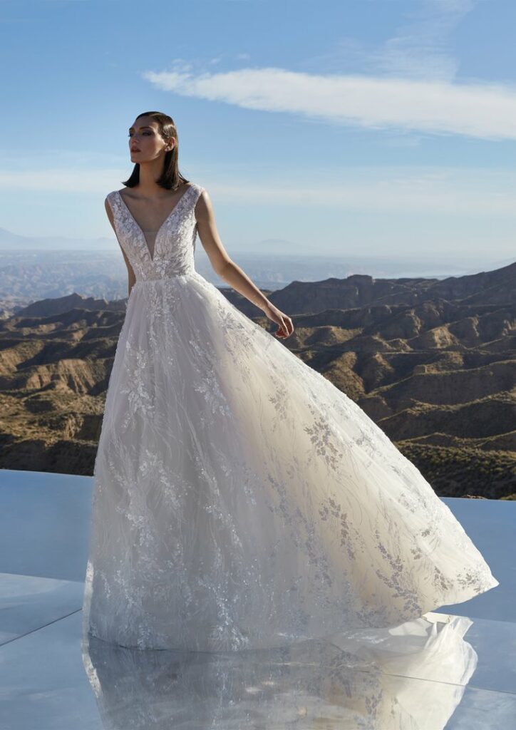 A-Linien-Brautkleid mit V-Ausschnitt und floraler Spitze vor einer Berglandschaft