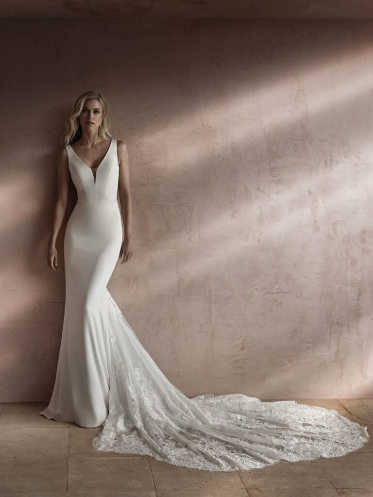 Schmales Brautkleid mit tiefem V-Ausschnitt, glattem Stoff und langer Spitzenschleppe