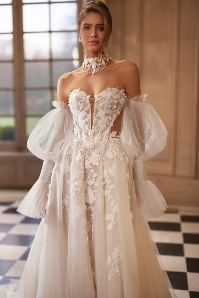 Brautkleid mit floraler Spitze, tiefem Ausschnitt und transparenten Puffärmeln