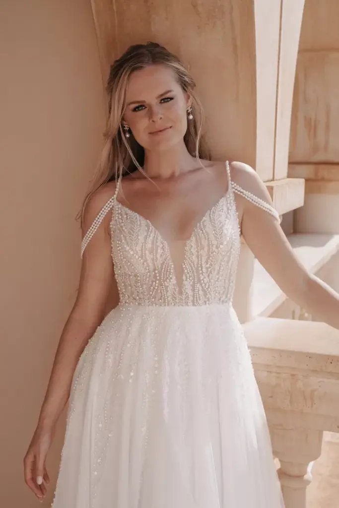 Detail des Brautkleids mit tiefem V-Ausschnitt und verzierten schmalen Trägern